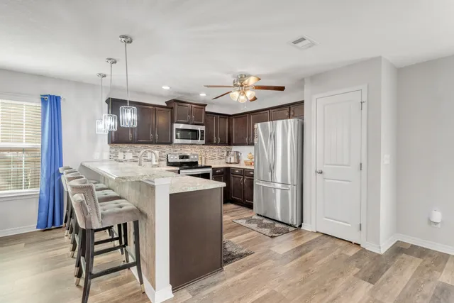 a kitchen with kitchen island granite countertop a sink a counter and cabinets