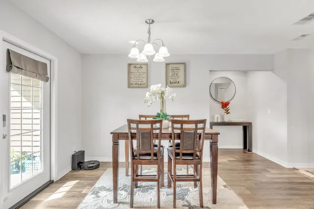 a view of a dining room with furniture a kitchen and chandelier