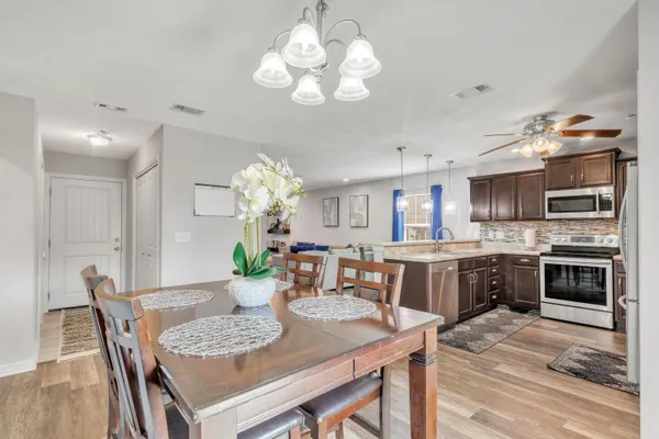 a living room with furniture a chandelier and a flat screen tv