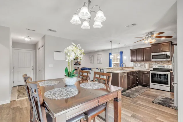 a living room with furniture a chandelier and a flat screen tv