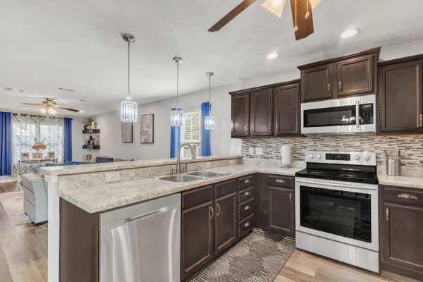 a kitchen with stainless steel appliances granite countertop a stove microwave and oven
