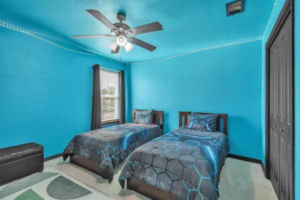 a bedroom with two beds and a chandelier