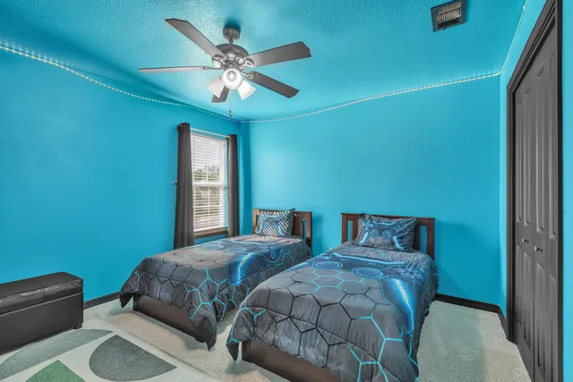 a bedroom with two beds and a chandelier