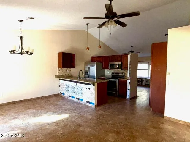 a kitchen with stainless steel appliances kitchen island granite countertop a refrigerator and a stove top oven