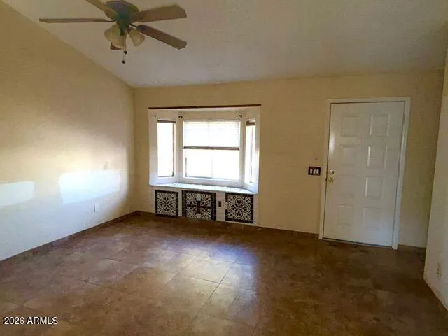 an empty room with windows and fan