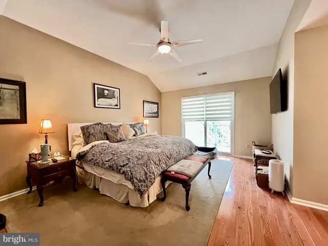 a living room with a bed furniture and a flat screen tv