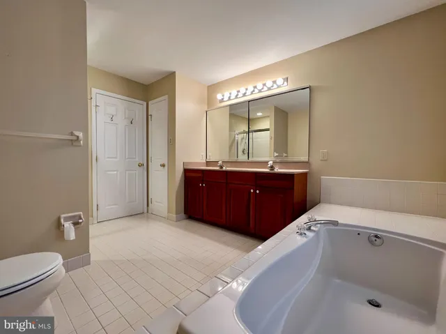 a spacious bathroom with a tub sink and mirror