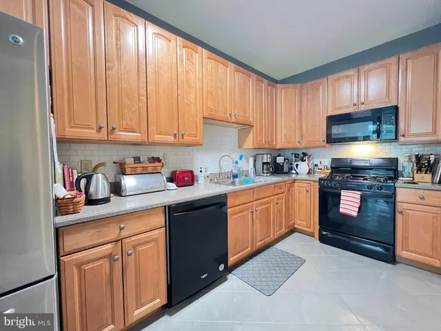 a kitchen with granite countertop a stove top oven sink and cabinets