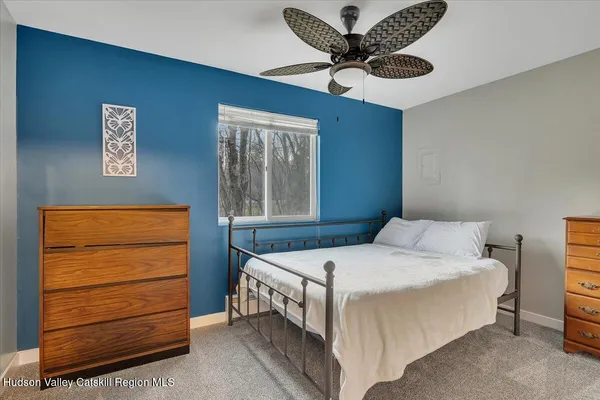 a bedroom with a bed a dresser and a window