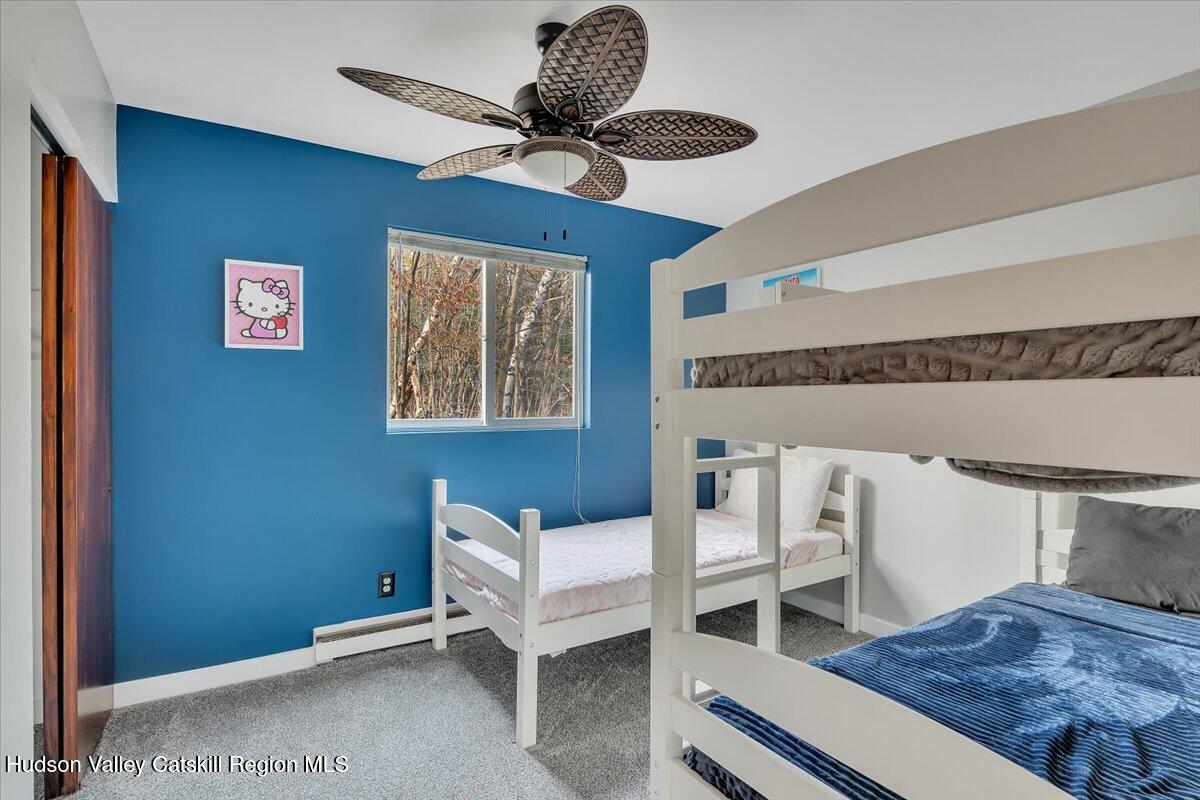 114 Ford Hill Road Hunter, NY 12442 - Photo 16 of 40 a bedroom with a bed and a chandelier