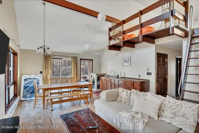 a living room with furniture a large window and a chandelier