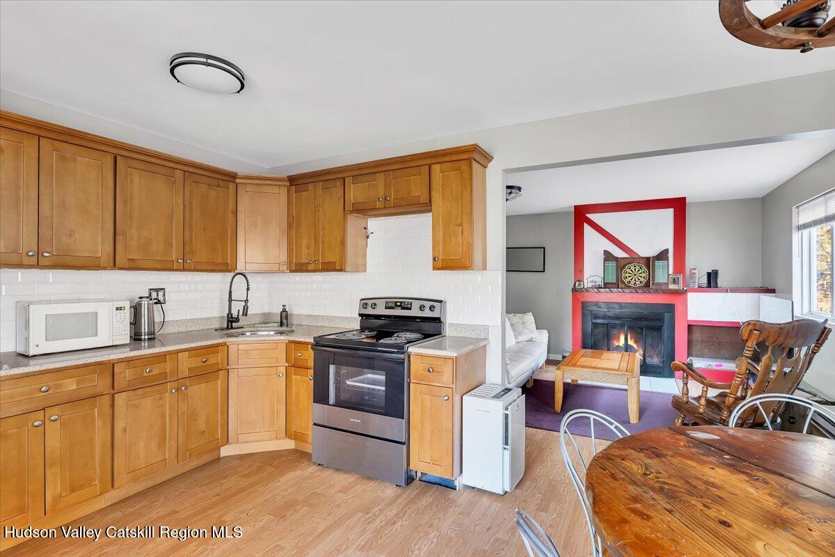 114 Ford Hill Road Hunter, NY 12442 - Photo 6 of 40 a kitchen with stainless steel appliances granite countertop a stove top oven a sink dishwasher and cabinets with wooden floor
