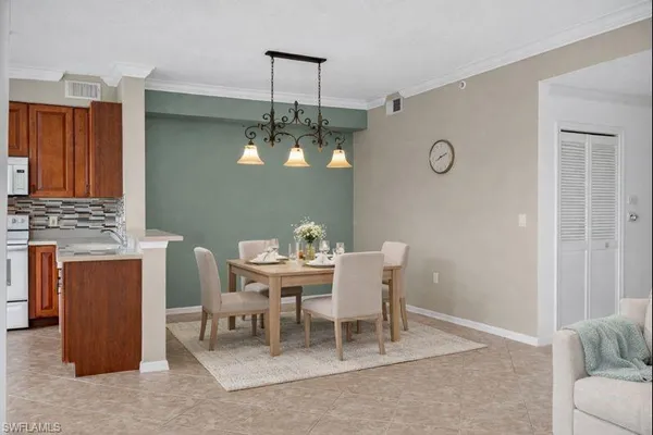 a dining room with furniture a chandelier and wooden floor