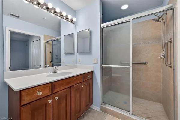 a bathroom with a shower sink and mirror