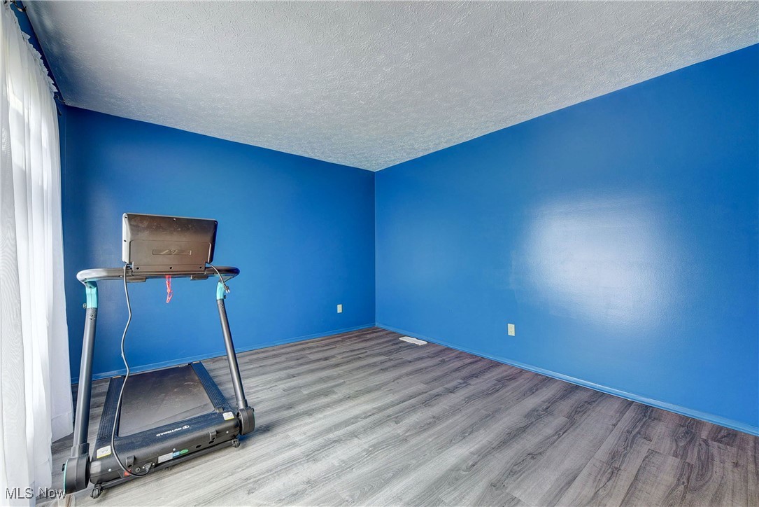 10810 Priem Road Strongsville, OH 44149 - Photo 25 of 35 Exercise room featuring light wood-type flooring and a textured ceiling