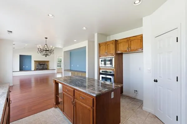 a kitchen with stainless steel appliances granite countertop a sink and a refrigerator