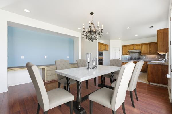 384 Millbrook Street Hanford, CA 93230 - Photo 16 of 59 a view of a dining room with furniture and wooden floor