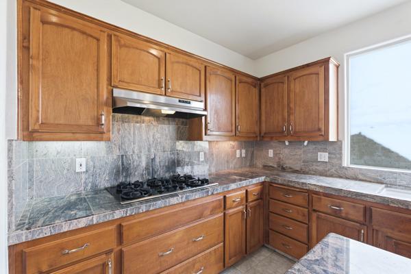 384 Millbrook Street Hanford, CA 93230 - Photo 17 of 59 a kitchen with stainless steel appliances granite countertop a sink a stove and cabinets
