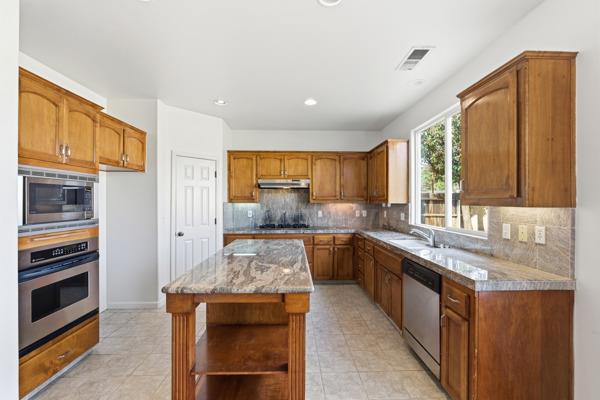 384 Millbrook Street Hanford, CA 93230 - Photo 21 of 59 a kitchen with stainless steel appliances granite countertop a stove sink and cabinets