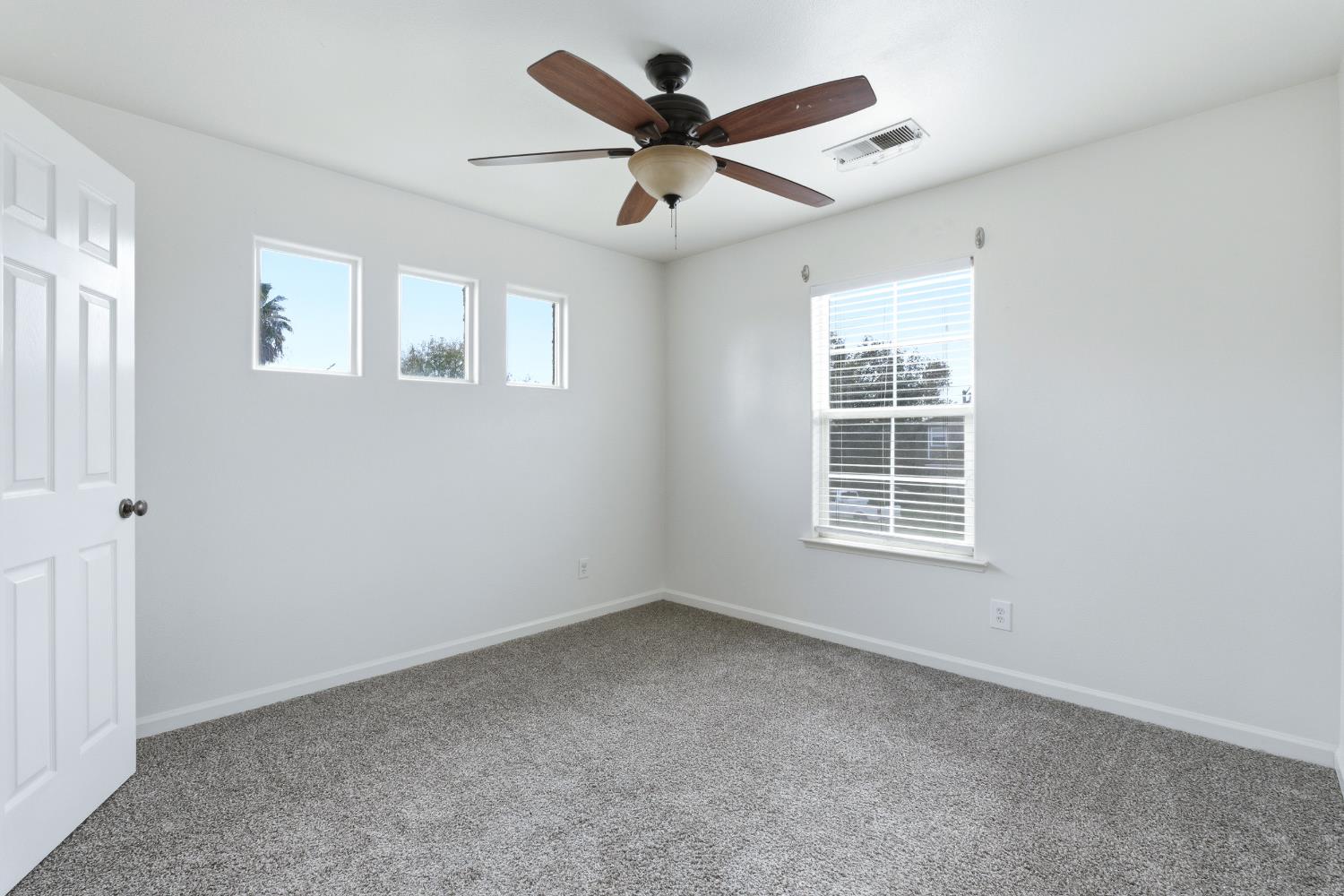 384 Millbrook Street Hanford, CA 93230 - Photo 35 of 59 an empty room with chandelier fan and windows