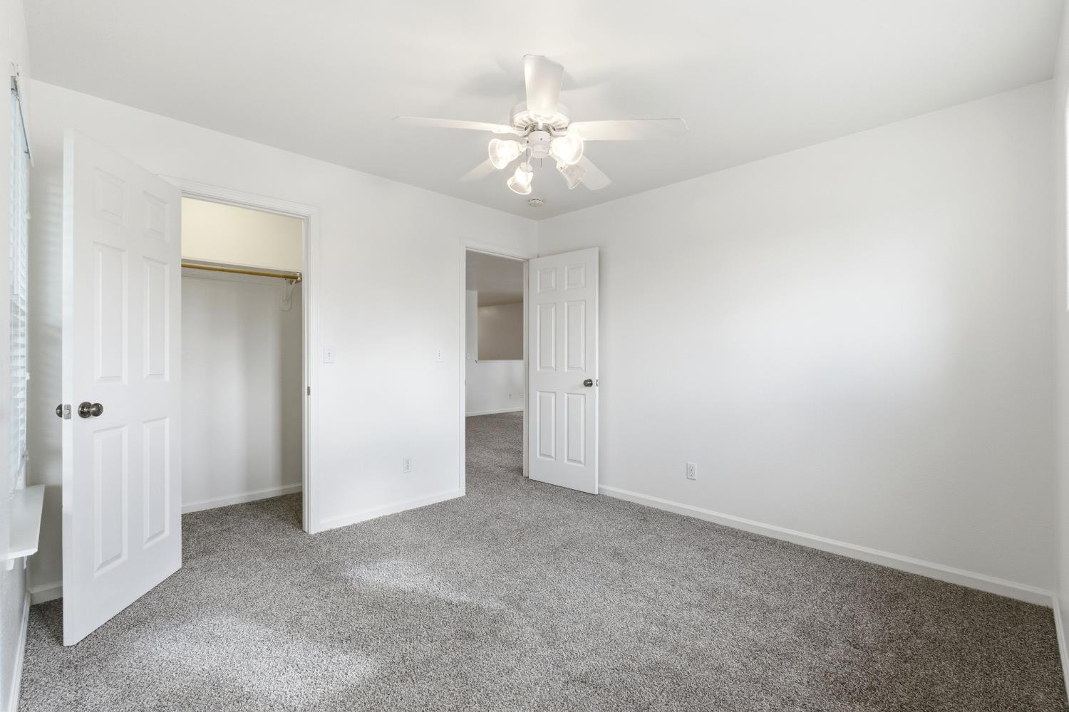 384 Millbrook Street Hanford, CA 93230 - Photo 39 of 59 an empty room with a chandelier fan and closet