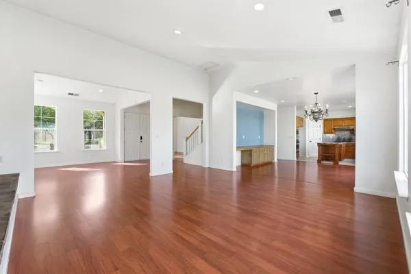 a view of empty room with wooden floor and windows