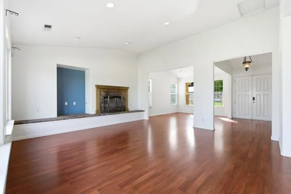 a view of an empty room with wooden floor and a cabinet
