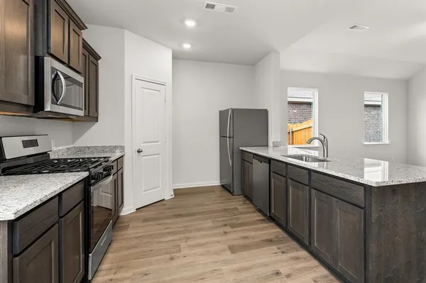 a kitchen with stainless steel appliances granite countertop a stove and a refrigerator