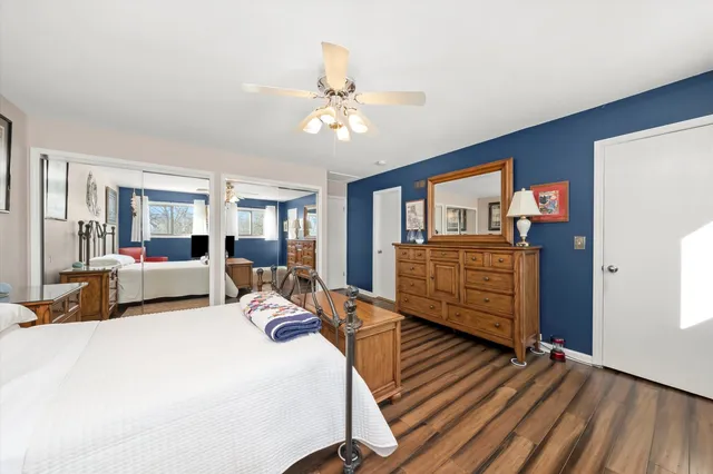 a bedroom with a bed dresser and a large window