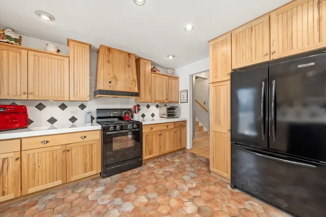 a kitchen with granite countertop a refrigerator stove top oven and sink