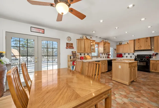 a living room with stainless steel appliances furniture cabinets and a kitchen view