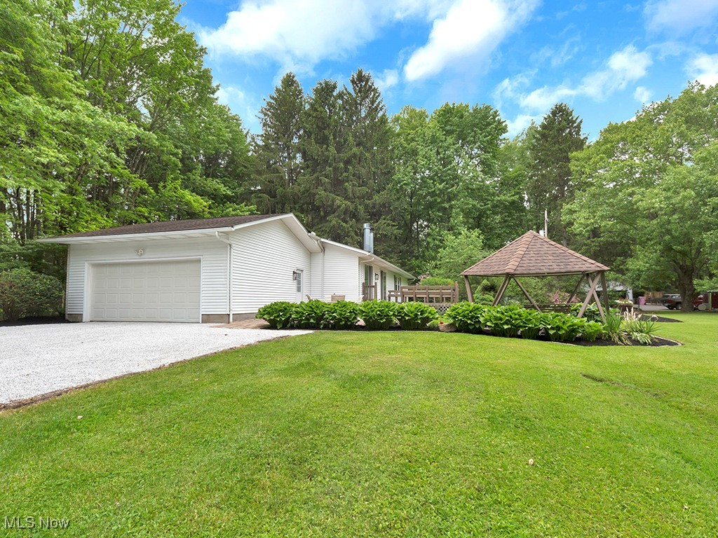 11050 Bell Road Newbury, OH 44065 - Photo 27 of 38 View of home's exterior (east side) featuring a gazebo, the back lawn, driveway, view of garage