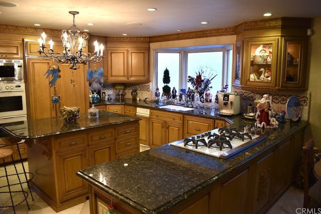 a kitchen with granite countertop a sink and a refrigerator