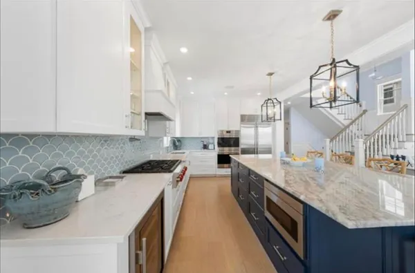 a large kitchen with sink a counter top space and stainless steel appliances