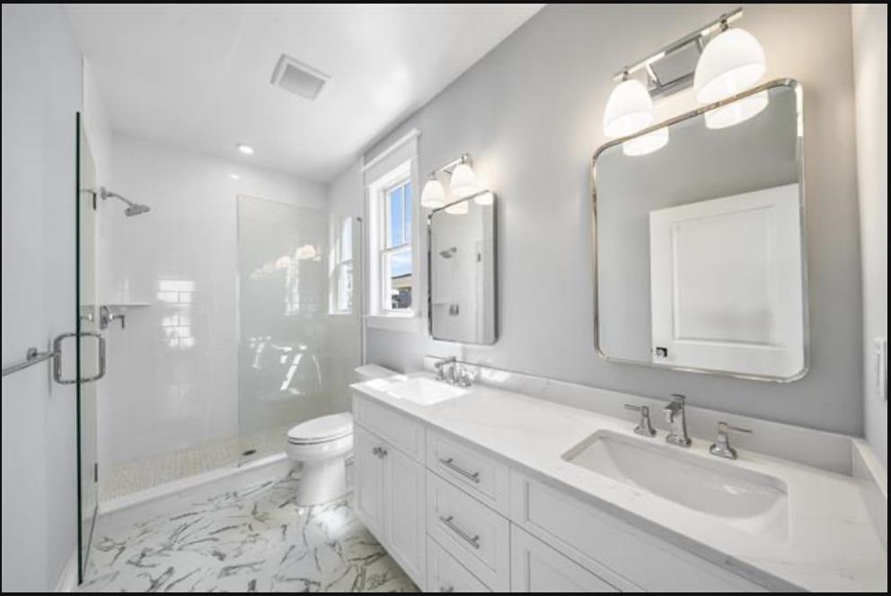 174 23rd Street Avalon, NJ 08202 - Photo 12 of 15 a bathroom with a double vanity sink mirror double shower and a toilet