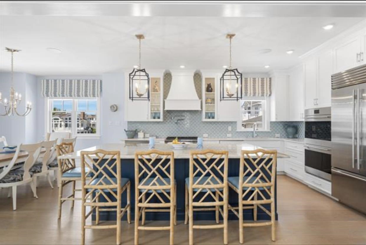 174 23rd Street Avalon, NJ 08202 - Photo 21 of 23 a kitchen with stainless steel appliances kitchen island granite countertop a table and chairs in it