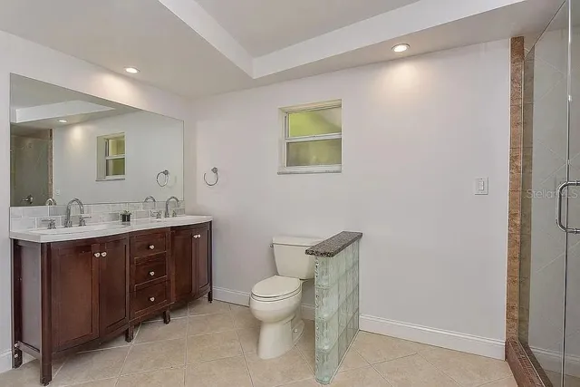 a spacious bathroom with a toilet sink and mirror