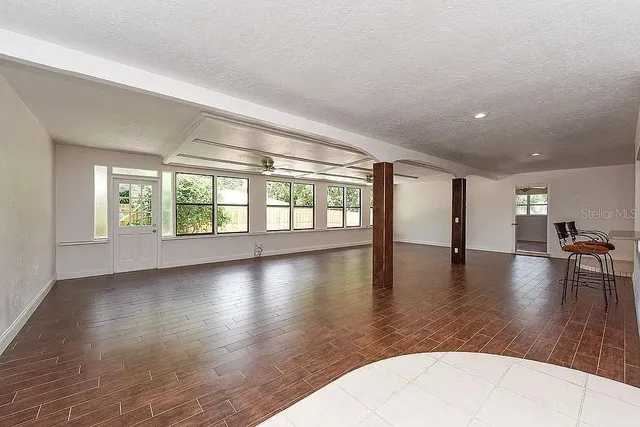 a view of empty room with wooden floor and floor to ceiling window