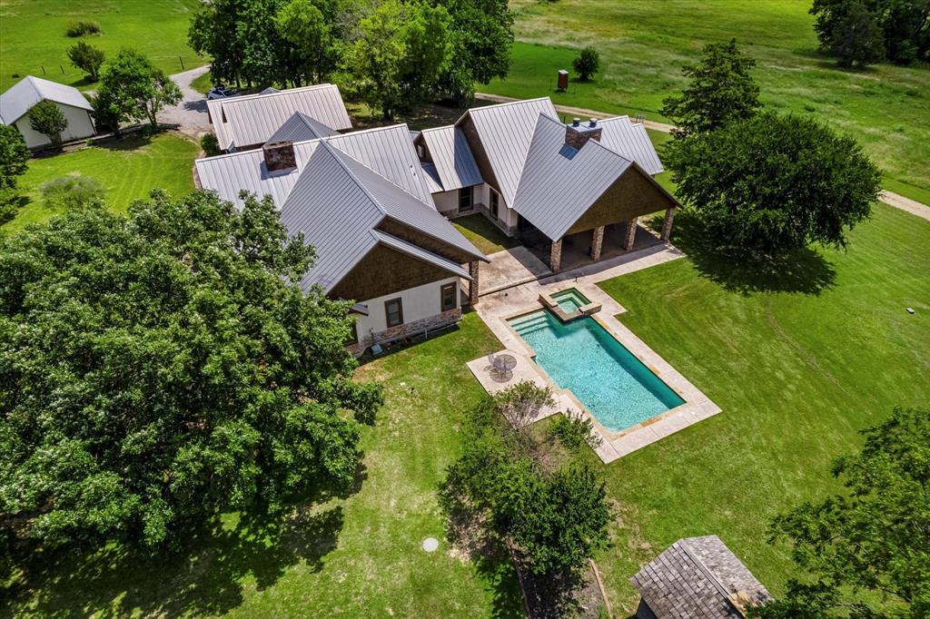 an aerial view of a house with pool yard and mountain view in back