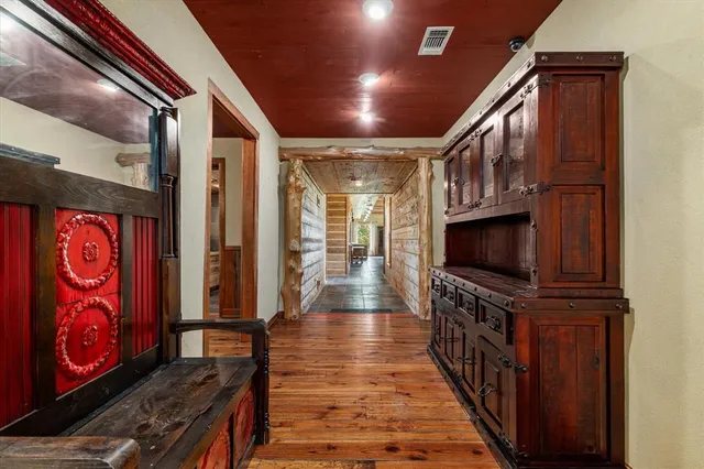 a view of a hallway with wooden floor and flat screen tv