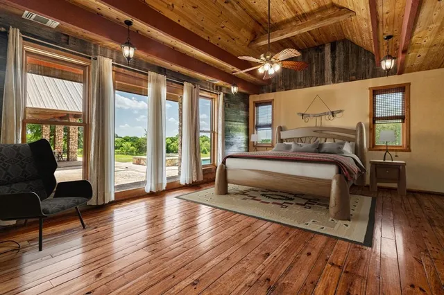 a bedroom with a bed wooden floor and a view of bedroom