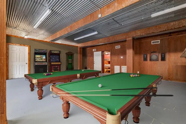 a room with pool table and windows