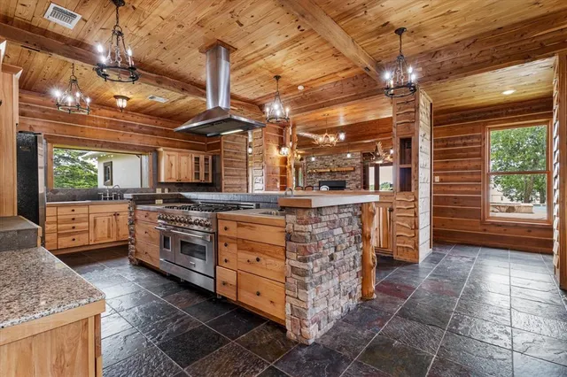 a kitchen with stainless steel appliances granite countertop a stove a sink and a refrigerator