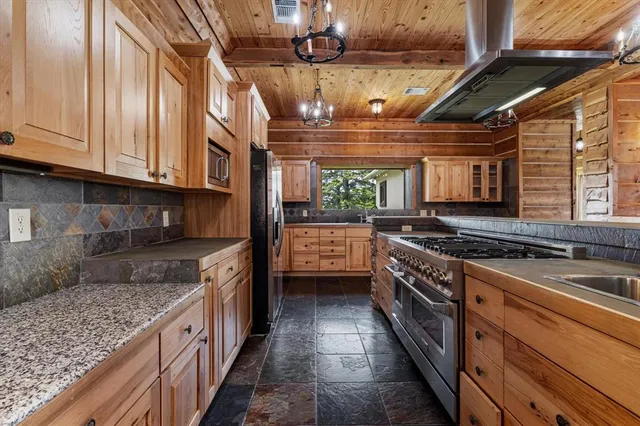 a kitchen with stainless steel appliances granite countertop a stove a sink and a granite counter tops