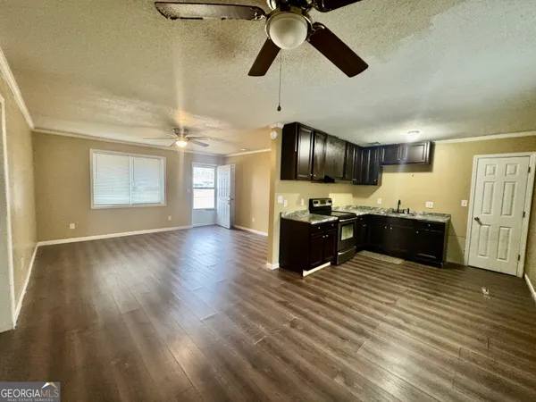 a kitchen with stainless steel appliances kitchen island granite countertop wooden floors a stove and a sink