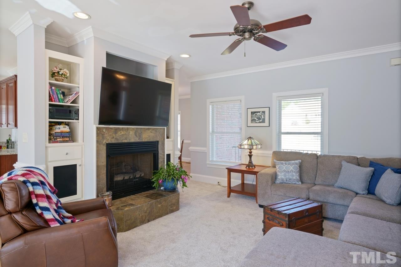 4300 Irene Way Raleigh, NC 27603 - Photo 8 of 50 a living room with furniture a flat screen tv and a fireplace