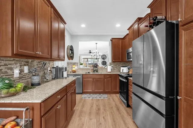a kitchen with stainless steel appliances granite countertop refrigerator sink and cabinets