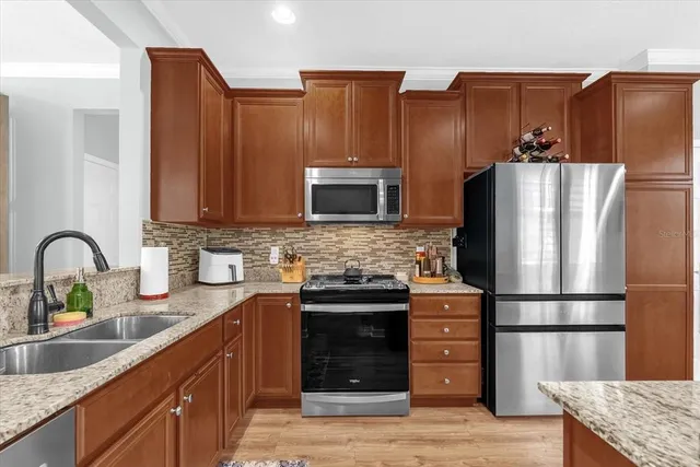 a kitchen with stainless steel appliances granite countertop a refrigerator stove and sink