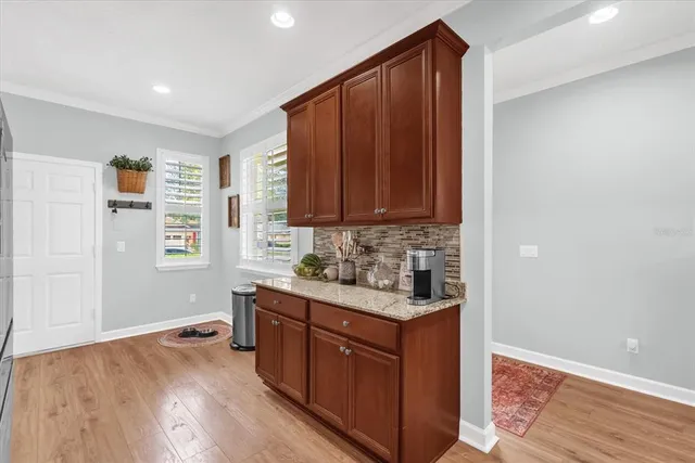 a kitchen with stainless steel appliances granite countertop a sink cabinets and wooden floor