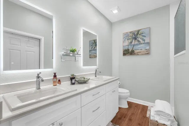 a bathroom with a granite countertop sink mirror vanity and toilet